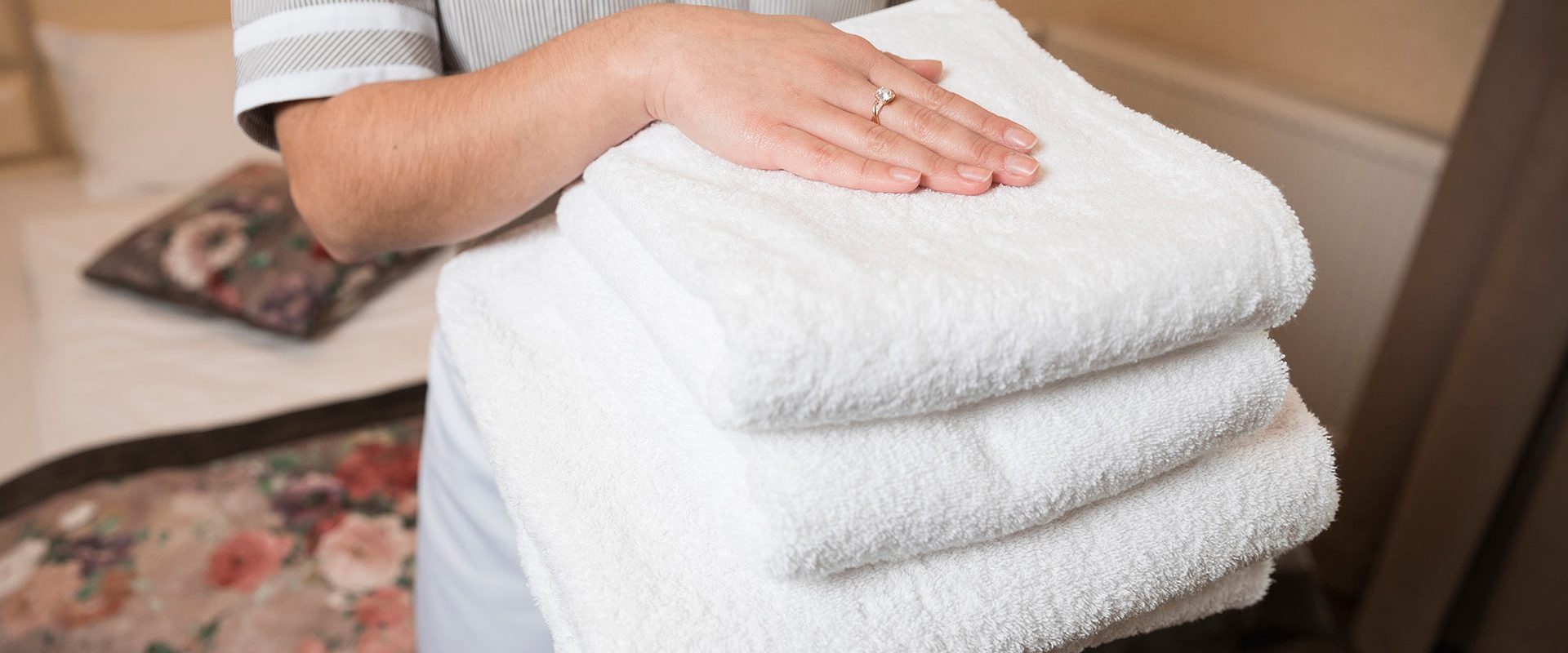 close-up-female-chambermaid-holding-clean-soft-folded-towel-hand-banner-4